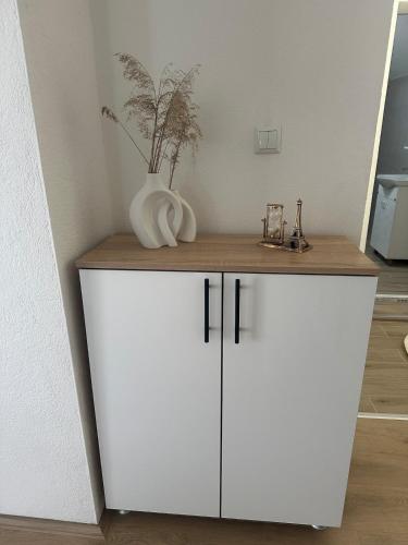 a white cabinet with a vase on top of it at Daily corner in Bujanovac