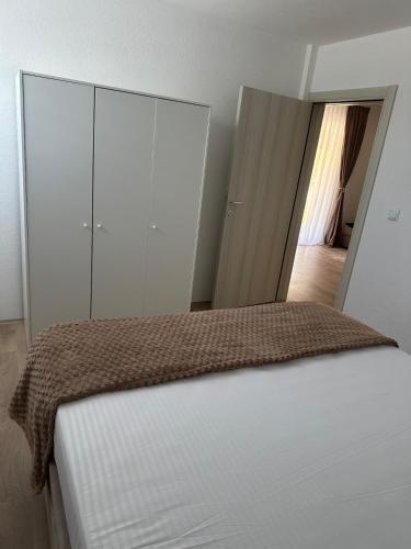a bedroom with a bed with white cabinets and a doorway at Daily corner in Bujanovac