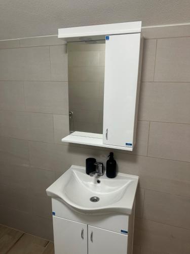 a bathroom with a white sink and a mirror at Daily corner in Bujanovac