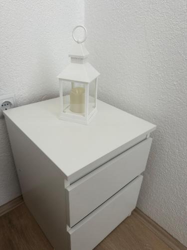 a white dresser with a lamp on top of it at Daily corner in Bujanovac
