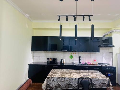 Una cocina con gabinetes negros y encimera. en Hostel Barakat, en Samarkand