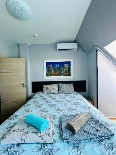 a bedroom with a bed with a blue comforter at Joy Station Appartment 2 in Sofia