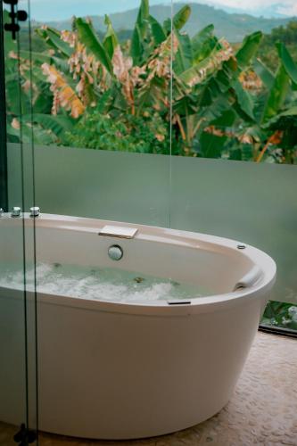 a bath tub in a room with a window at Ecoparadise Hotel in Pereira