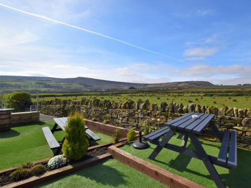 a picnic table in a garden with a view of a cemetery at 1 bed property in Holmfirth 82194 in Meltham
