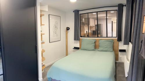 une petite chambre avec un lit et une fenêtre dans l'établissement Appartement coeur centre ville et parking gratuit, à Bayeux