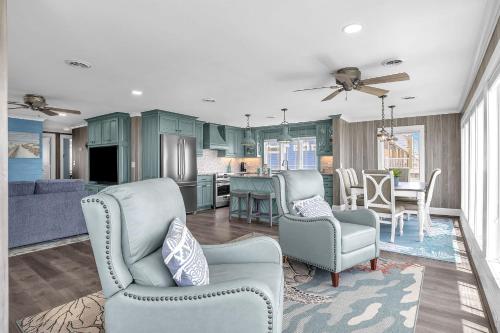 a kitchen and living room with blue cabinets at Reelaxing in Oak Island