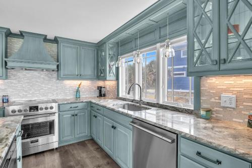 a kitchen with blue cabinets and a sink at Reelaxing in Oak Island