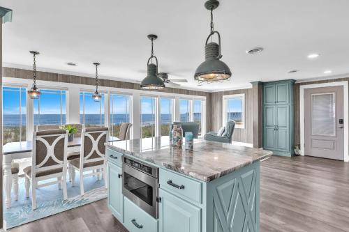 a kitchen with blue cabinets and a dining room with a table at Reelaxing in Oak Island
