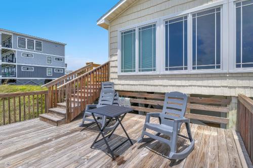 a deck with four chairs and a table on it at Reelaxing in Oak Island