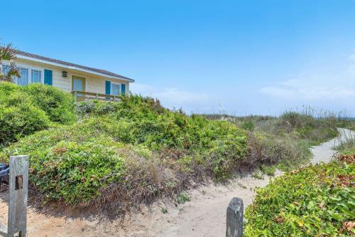 a house on top of a hill with a dirt road at Reelaxing in Oak Island