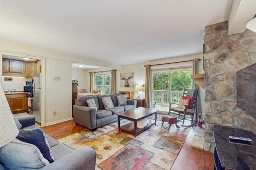 a living room with a couch and a stone fireplace at Bee Branch 14 in Sugar Mountain