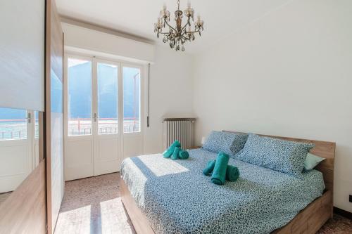 ネッソにあるAnna's Balcony on Lake Como - By Breva Collectionsのベッドルーム1室(青い枕とシャンデリア付きのベッド1台付)