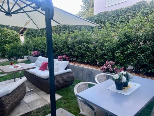 a patio with a table and chairs and an umbrella at Romantic Space in Nussbaumen