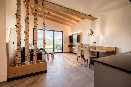 une cuisine et une salle à manger avec un bureau et une table à manger dans l'établissement Stabingerhof Chalets & Apartment-Farm stay, à Bressanone