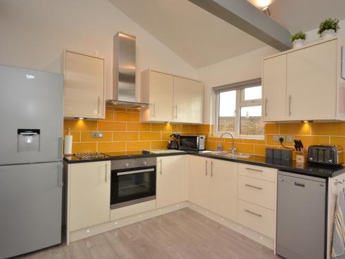 a kitchen with white appliances and yellow tiles at 3 Bed in Moorlinch 56284 in Greinton