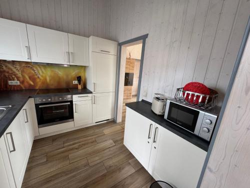 a kitchen with white cabinets and a black counter top at Seeschwalbe 78 Kompassweg in Rechlin