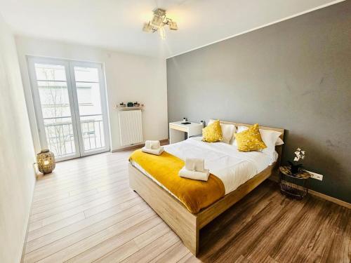 a bedroom with a large bed with yellow pillows at Chic 2BR easy access to the train station-2b in Luxembourg