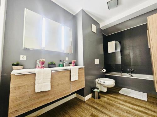 a bathroom with a toilet and a sink and a tub at Chic 2BR easy access to the train station-2b in Luxembourg