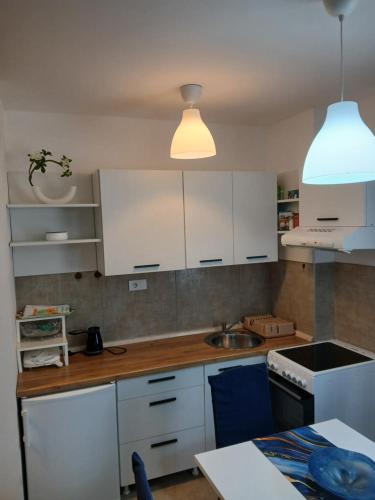 a kitchen with white cabinets and a sink at Apartman s parkingom, blizu Akva parka, Natura Lux - Green Hill, Sokobanja in Soko Banja