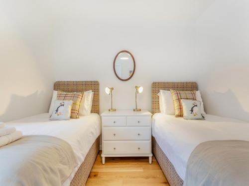 two twin beds in a room with a mirror at Sandakan in Ardersier