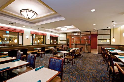 a restaurant with tables and chairs and a bar at Holiday Inn & Suites Winnipeg Downtown by IHG in Winnipeg