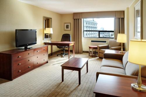 a living room with a couch and a tv at Holiday Inn & Suites Winnipeg Downtown by IHG in Winnipeg