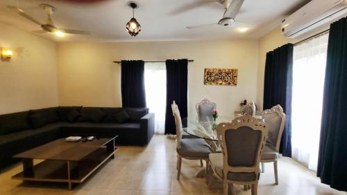 a living room with a couch and a table at Haven Lodge - 4BR Luxurious Spanish Villa in Lahore in Lahore