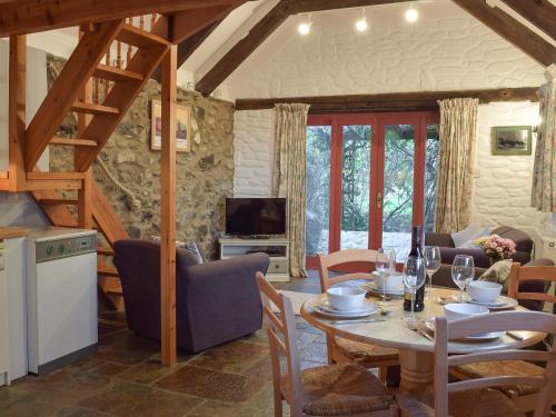 eine Küche und ein Esszimmer mit Tisch und Stühlen in der Unterkunft Beats Cottage in Llangwm
