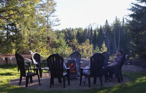 a woman sitting at a table with chairs at Le Mitik Tremblant - SPA - LACS - PLAGES - JEUX in Saint-Rémi-dʼAmherst