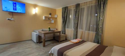a room with two beds and a desk and a television at Къща за гости "Венито" in Sinemorets