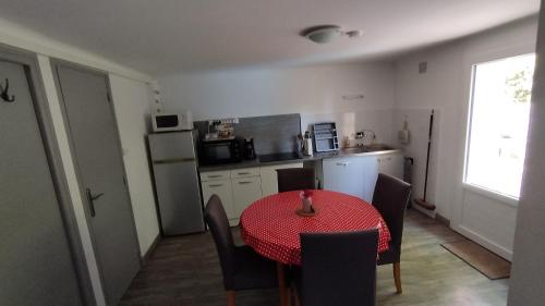 a kitchen with a red table and chairs in a room at Gîte le Tilleul in Les Farges