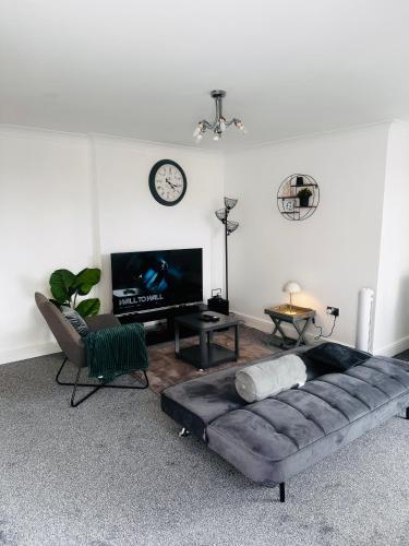 a living room with a couch and a flat screen tv at Enjoy city living in this one-bedroom flat, complete with a balcony and secure parking in Birmingham city center in Birmingham