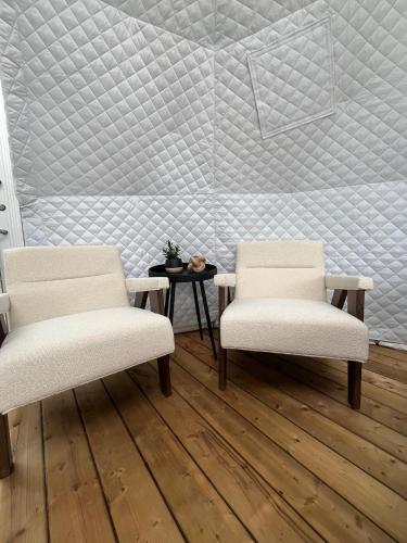 two white chairs and a table in a room at Grotto Getaway in Miller Lake