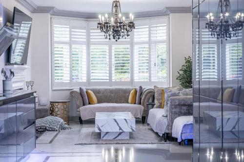 a living room with a couch and a chandelier at Chingford Manor in Chingford