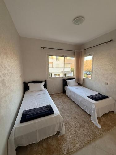 a bedroom with two beds and a window at Luxury apartment with a pool in Imi Ouaddar