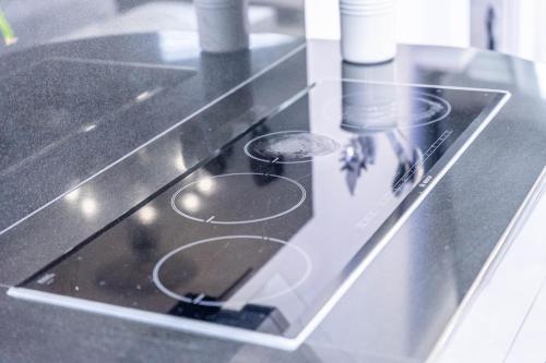a glass counter top with a stove top oven at Chingford Manor in Chingford