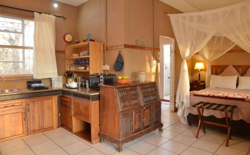 a kitchen with a sink and a bed in a room at Muchenje Self Catering Cottages in Muchenje
