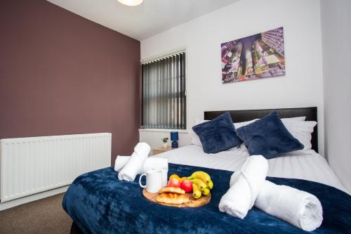 a bedroom with a bed with a tray of fruit on it at Chic 3BR Apartment - City Views, Fast WiFi & Close to Train Station! in Newcastle upon Tyne