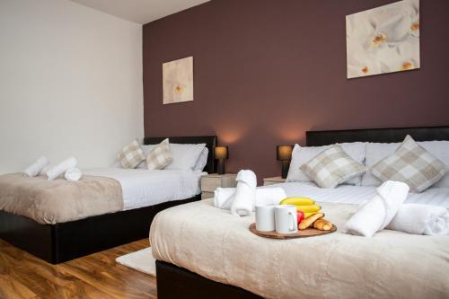 a bedroom with two beds with a tray of food at Chic 3BR Apartment - City Views, Fast WiFi & Close to Train Station! in Newcastle upon Tyne