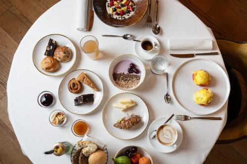 a white table with plates of food on it at Cerana Relax Hotel in Madonna di Campiglio