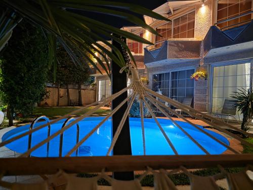 a swimming pool in front of a house at Aloha Apartments with pool in Skopje