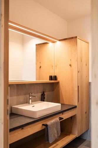 a bathroom with a sink and a mirror at Stabingerhof Chalets & Apartment-Farm stay in Bressanone