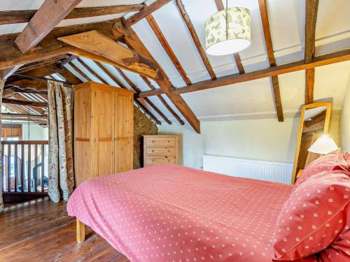 a bedroom with a pink bed and a wooden ceiling at 3 Bed in Ilfracombe GRAIC in West Down