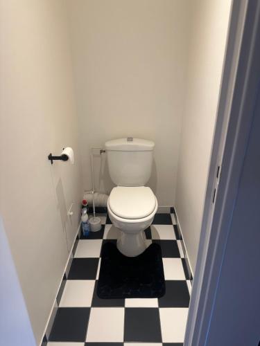 La salle de bains est pourvue de toilettes au sol en damier noir et blanc. dans l'établissement Appartement Paris 16, à Paris