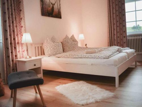 a bedroom with a white bed and a chair at Country love -Holiday on the horse farm- in Frauenkron