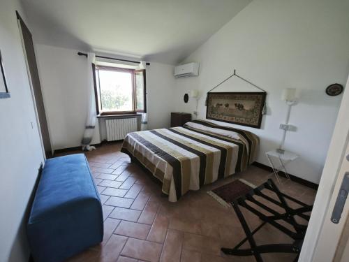a bedroom with a bed and a blue couch at R22 - Casa Geranio: delizioso appartamentino in Marcelli