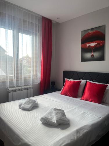 a bedroom with a large bed with red pillows at Valor in Zlatibor