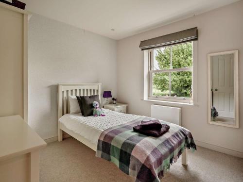 a bedroom with a bed with a teddy bear on it at 4 Bed in Bourton-on-the-Water 62039 in Bourton on the Water