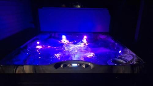 a hot tub in a dark room with lights in it at Solitude Junction in Opdyke