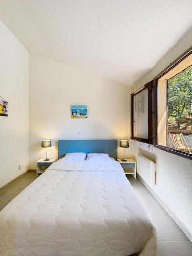 - un grand lit blanc dans une chambre avec deux lampes dans l'établissement Résidence Coulemelles - Maison mitoyenne 6 pers, cote Atlantique, Lacanau océan MAE-1091, à Lacanau